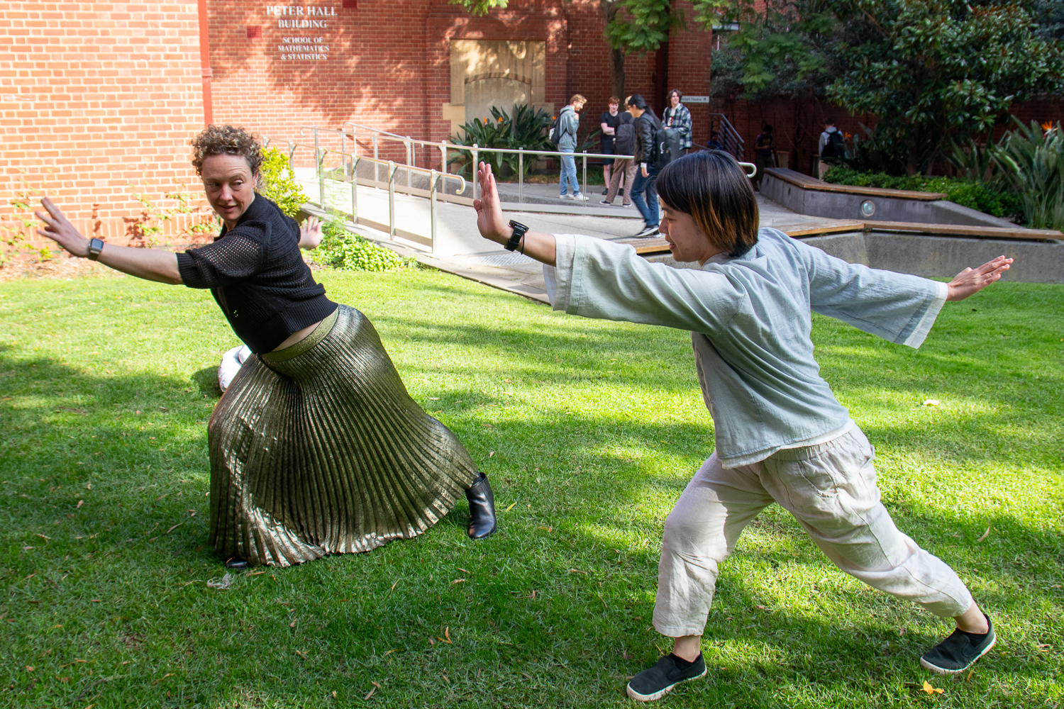 Two UniMelb academics showing each other kung fu moves (2024)